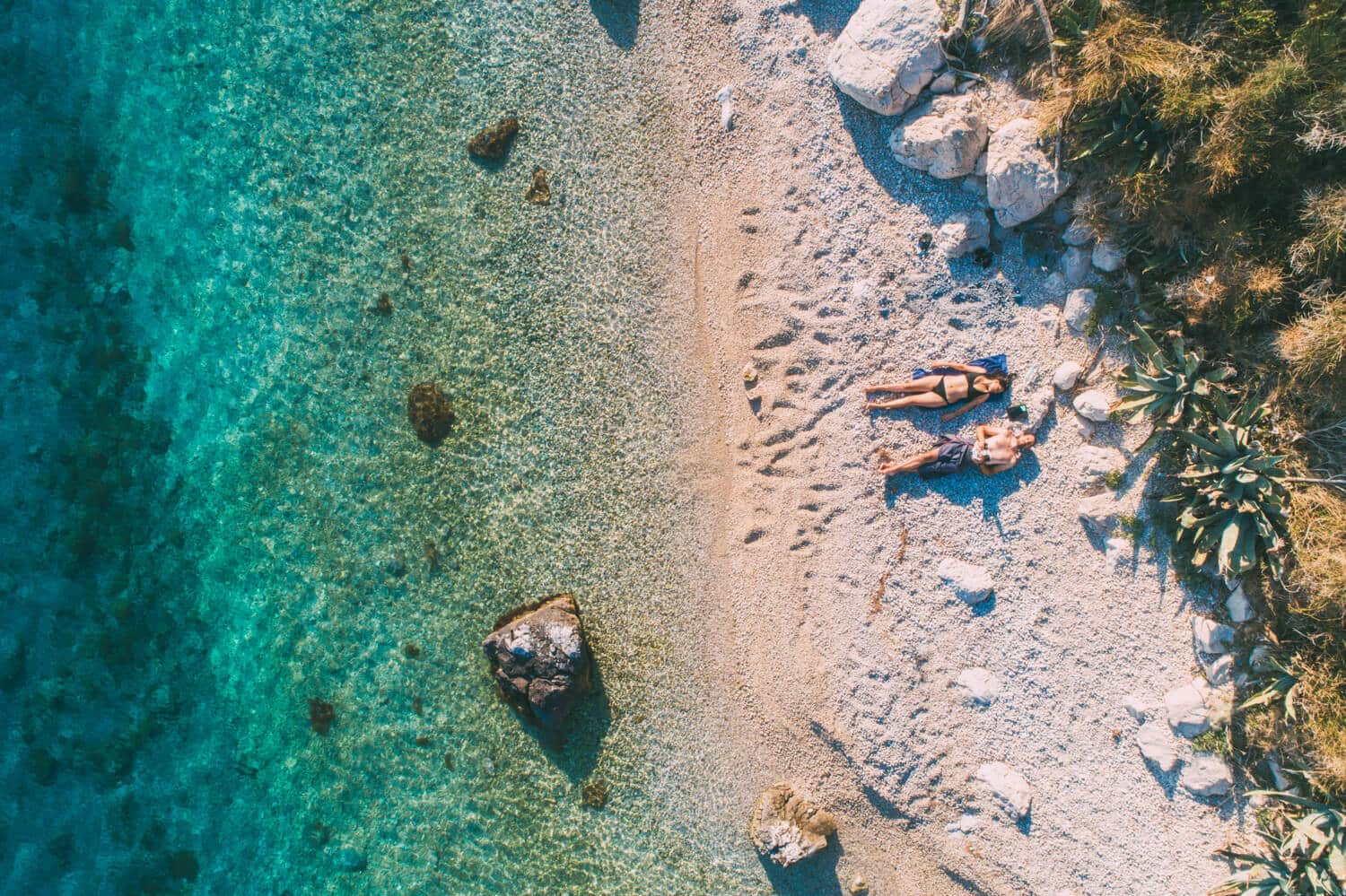 makarska riviera beaches, a couple lying on the beach in croatia
